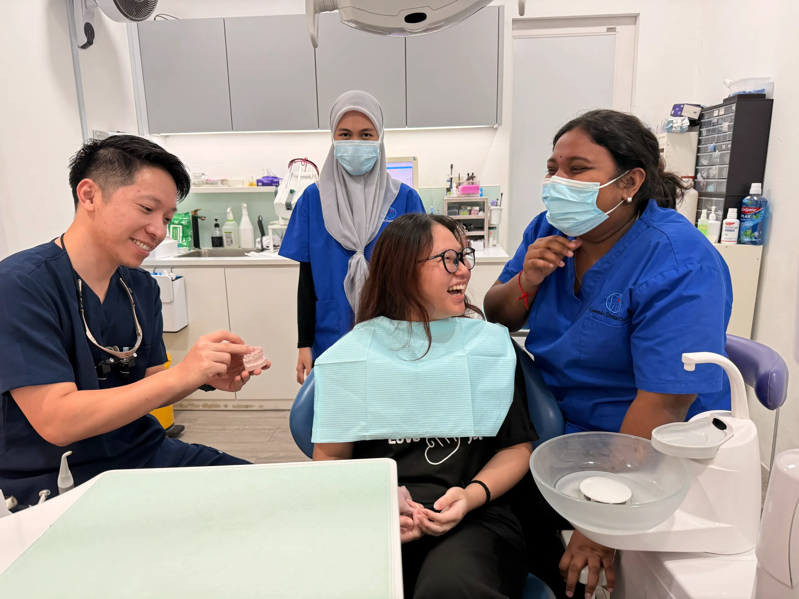 Dentist and staff consulting with a smiling patient